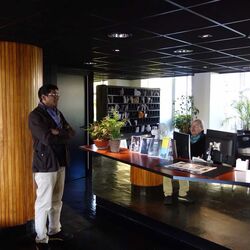 Eine stehende und eine sitzende Person in einem Gebäude