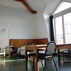 Sessel mit Tisch und einem Bett im Hintergrund